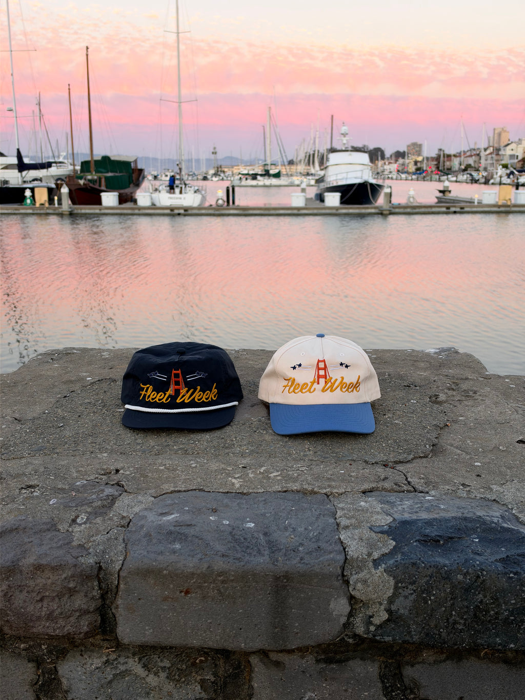 Navy rope and cream and denim Fleet Week hats beside a marina